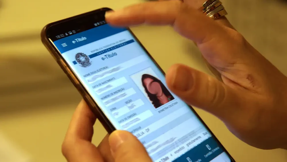 Título de eleitor ao lado de urna eletrônica