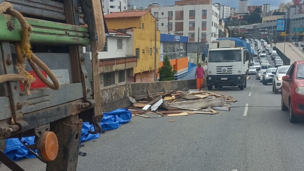 Carga de madeirite cai de caminhão e interdita parcialmente trânsito na Av. Cristiano Machado